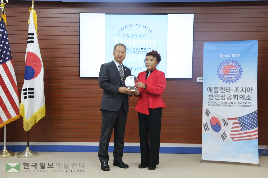 한오동 회장이 엄수나 전 회장에게 감사패를 전하고 있다.