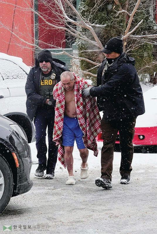  미 시민권자인 스캇 타오(가운데)가 지난 18일 영하의 날씨 속에 반바지 속옷 차림으로 ICE 요원들에게 끌려나오고 있다. [로이터]