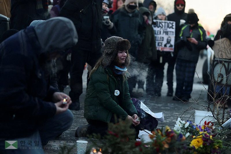 2026년 1월 24일 미네소타주 미니애폴리스. 알렉스 프레티(Alex Pretti)로 신원이 확인된 남성이 자신을 체포하려던 연방 요원들의 총격으로 사망한 현장에 마련된 임시 추모소 옆에서, 한 여성이 슬퍼하고 있다. 로이터