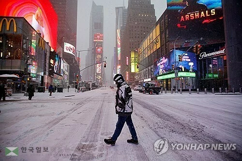  25일 눈폭풍 영향권에 든 미국 뉴욕 타임스퀘어 광장을 한 시민이 걷고 있다.(로이터)