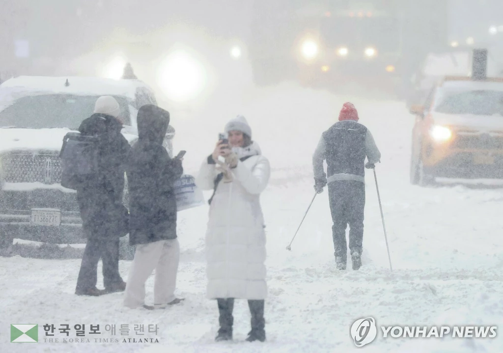 눈폭풍이 미국을 휩쓴 25일 뉴욕시 타임스퀘어에서 한 시민이 스키로 이동하고 있다. <연합뉴스>