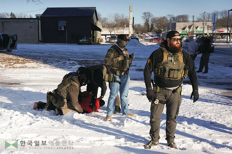  미네소타주에서 대대적 이민 단속이 계속되고 있는 가운데 지난 27일 세인트폴 지역에서 ICE 요원들이 한 남성을 체포하고 있다. [로이터]