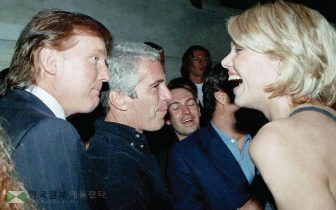  미성년자 성착취범 고 제프리 엡스타인이 보관해온 사진으로 도널드 트럼프 대통령(왼쪽)과 엡스타인(가운데)이 한 여성과 대화하고 있다. [로이터]