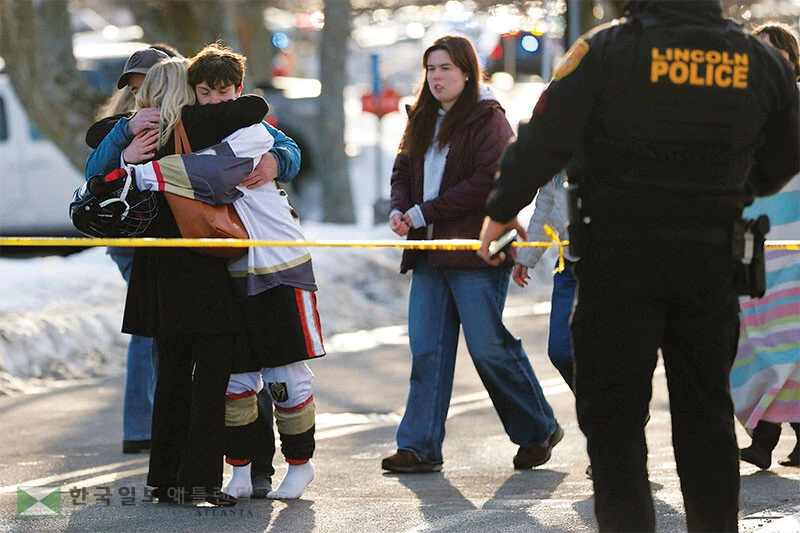  지난 16일 가정불화에 따른 총기난사 사건이 발생한 로드아일랜드주 포터킷의 고교 아이스하키 경기장 앞에서 충격을 받은 주민들이 서로를 위로하고 있다. [로이터]
