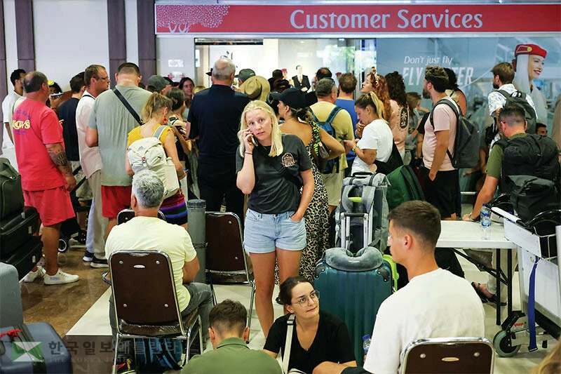  이란 전쟁의 여파로 두바이와 도하, 아부다비 등 중동 지역 주요 공항의 하늘길이 막히자 발리 공항에서 발이 묶인 이용객들이 에미레이츠 항공 카운터 앞에 모여 불안 속에 대기하고 있다. [로이터]