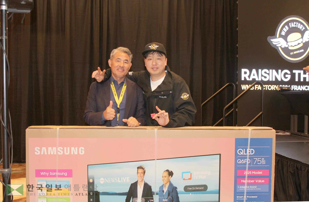 10일 웨스틴 애틀랜타 귀넷 호텔에서 열린 WnB팩토리 창립 11주년 기념 프랜차이즈 미팅 현장에서, 경품 추첨을 통해 75인치 TCL Google TV를 획득한 당첨자 ‘이상무가간다’의 이인기 상무와 트로이표 WnB팩토리 대표와 함께 기념 촬영을 하고 있다. 