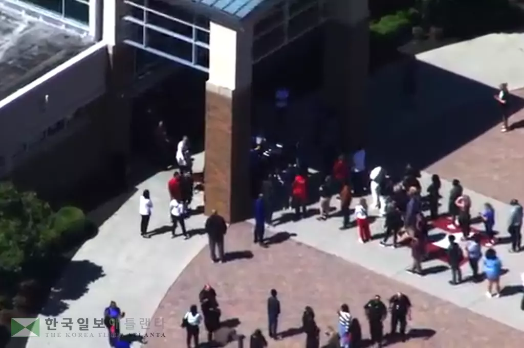 24일 오전 캅 카운티 힐그로브 고등학교에서 한 학생이 총기를 들고 등교한 사실이 알려지자 학생들이 급히 건물 밖으로 피신하고 있다.<사진=WSB-TV>