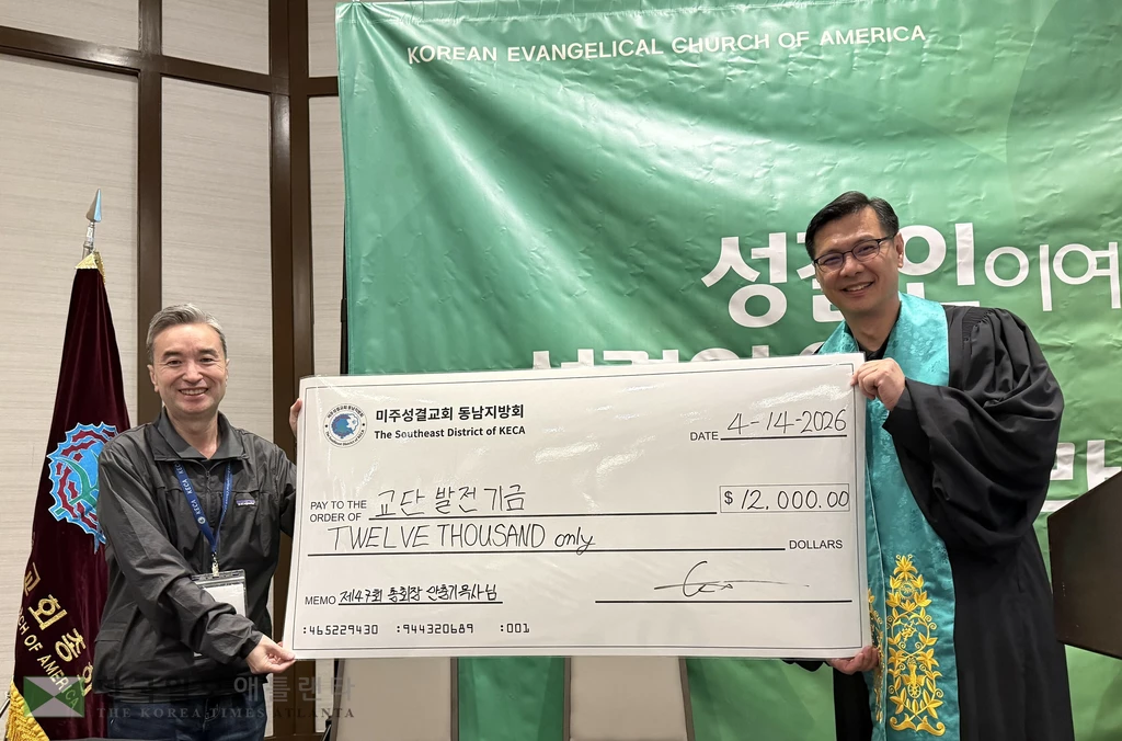 미주성결교회 동남지방회장 김종민 목사(왼쪽)이 교단 총회장 안충기 목사에게 후원금을 전달하고 있다.