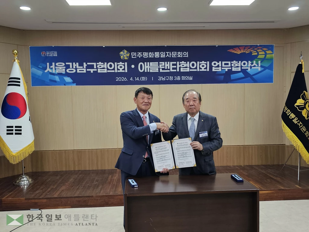 민주평통 이경철 애틀랜타협위회장(왼쪽)과 강신용 강남구협의회장이 업무협약을 체결하고 악수하고 있다.