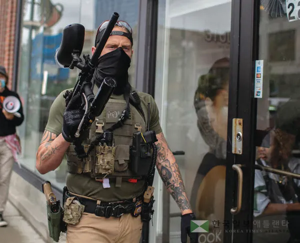  얼굴 복면을 하고 중화기를 든 연방 이민당국 요원의 모습. [로이터]