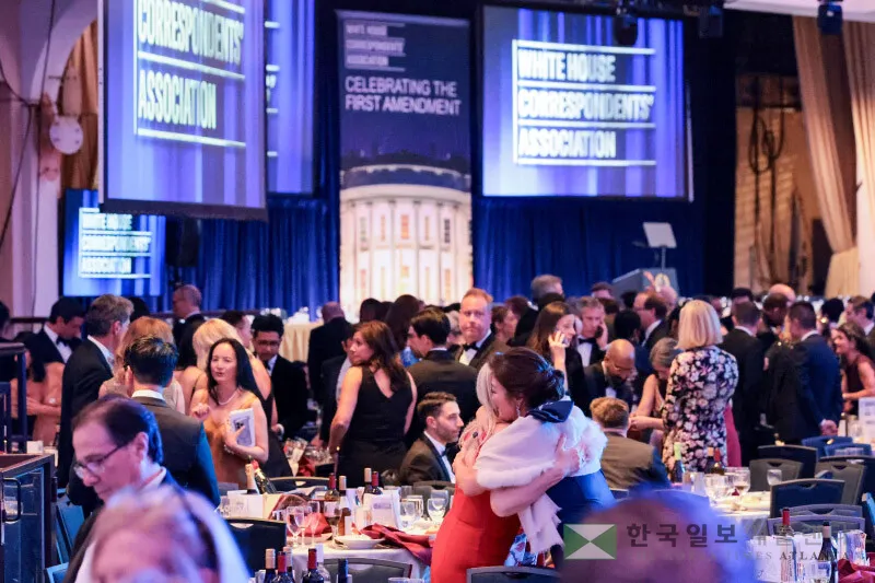 2026년 4월 25일, 워싱턴 DC에서 열린 연례 백악관 특파원 협회 만찬에서 총격 사건이 발생한 후 손님들이 포옹하고 있다. [로이터]