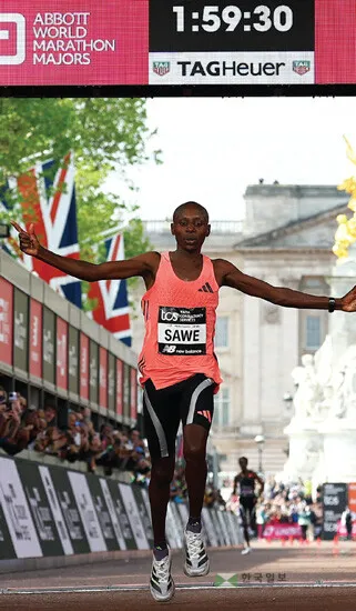  케냐의 사바스티안 사웨의 기록 경신 장면. 공인 기록 시계에 ‘1시간 59분 30초’가 표시돼 있다. [로이터]