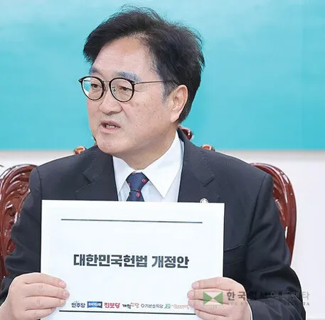  우원식 국회의장이 헌법 개정안을 들어보이고 있다. [연합]