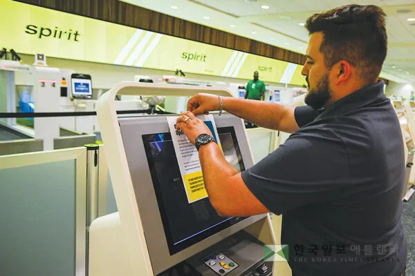  스프릿항공 직원이 지난 2일 플로리다주 올랜도 국제공항 카운터에서 스피릿항공 영업 중단을 알리는 사인판을 부착하고 있다. [로이터]