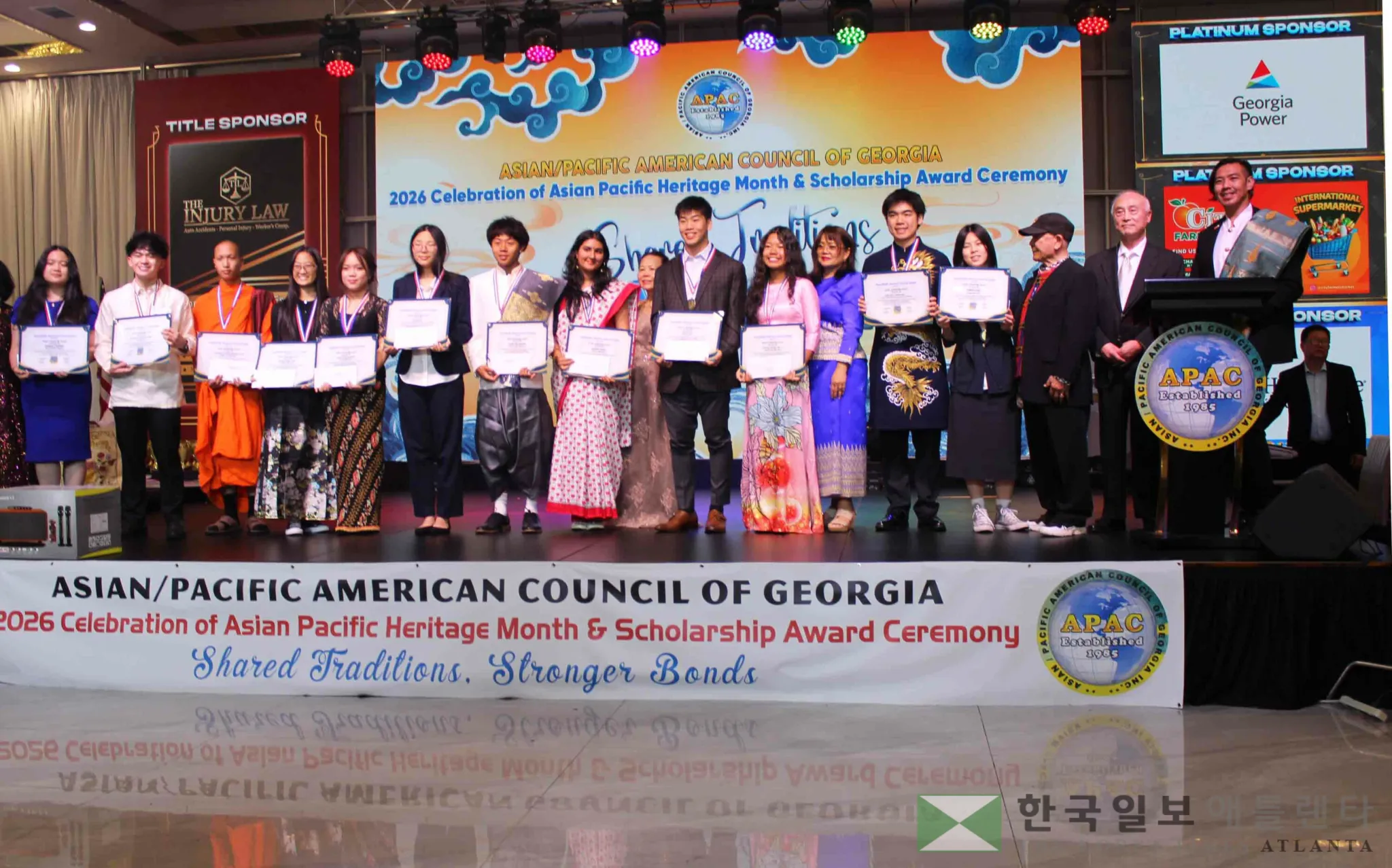 장학금 수여식(Scholarship Award Ceremony)에서 선발된 장학생들이 상장을 들고 단상에 모여 기념 촬영을 하고 있다.