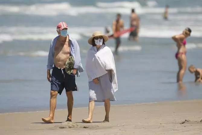 델타 변이의 확산으로 백신 접종자들도 여전히 주의를 해야 한다. 델마 해변을 찾은 주민들이 마스크를 쓰고 백사장을 거닐고 있다.   &lt;로이터>