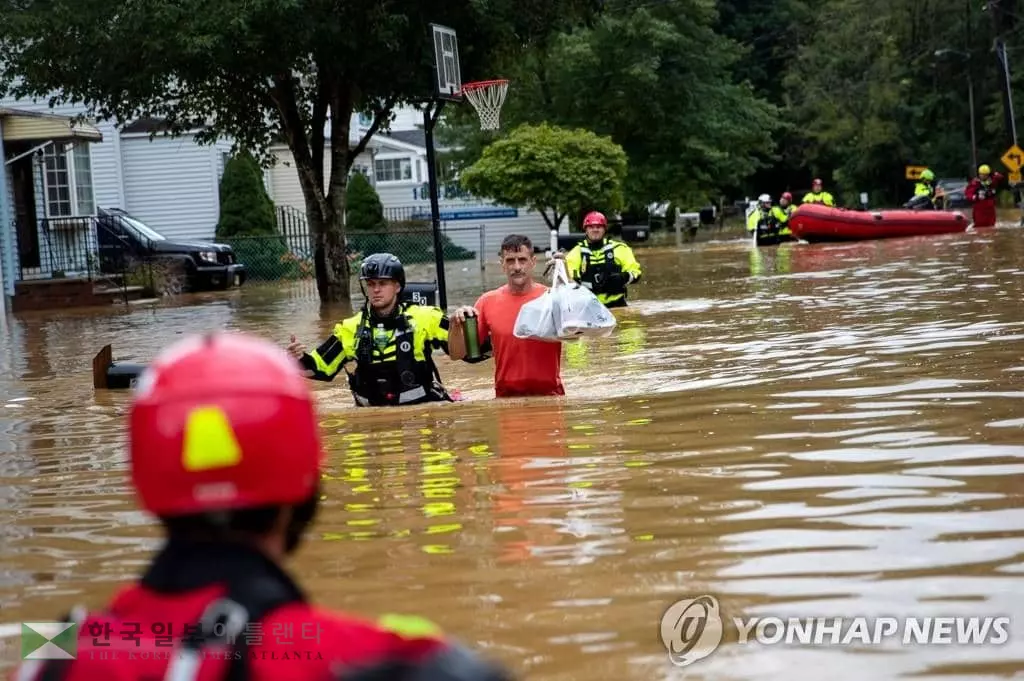 열대성 폭풍 '헨리'로 인한 홍수 피해 지역인 뉴저지주 헬메타의 침수된 주택가에서 22일 구조대가 주민들의 대피를 돕고 있다. 허리케인 헨리는 동북부에 상륙한 뒤에도 많은 비를 뿌려 곳곳에서 홍수와 정전 등 피해를 일으켰다.<연합뉴스>