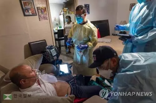 20일 텍사스주 휴스턴의 한 주택에서 텍사스 소방서 구급대원이 코로나19 환자의 상태를 점검하고 있다. [AFP=연합뉴스]