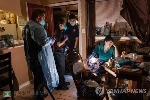 25일 텍사스주 휴스턴소방서의 구급요원들이 코로나19 증세를 보이는 여성을 병원으로 이송할 준비를 하고 있다. [AFP=연합뉴스]