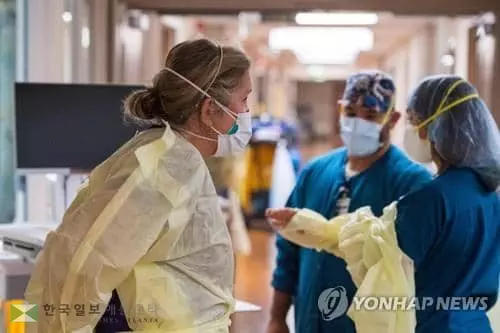 지난달 27일 미 캘리포니아 소노라의 한 병원에서 간호사들이 중환자실의 코로나19 환자를 살펴보기 전에 개인보호장비를 착용하고 있다. [AFP=연합뉴스]