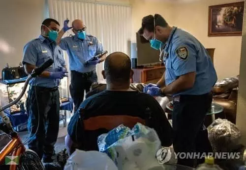 14일 텍사스주 휴스턴소방대 구급대원들이 코로나19에 감염된 40대 남성의 생체 신호를 검사하고 있다.