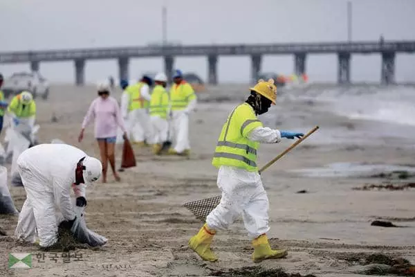 오렌지카운티 해안에서 지난 2일 발생한 대규모 기름 유출 사태의 여파가 계속되고 있는 가운데 환경 당국과 자원봉사자들을 중심으로 한 해변 정화 작업이 속도를 내고 있다. 7일 뉴포트비치 해변에서 인부들이 모래사장을 오염시킨 원유를 수거하는 작업을 펼치고 있다. [로이터]