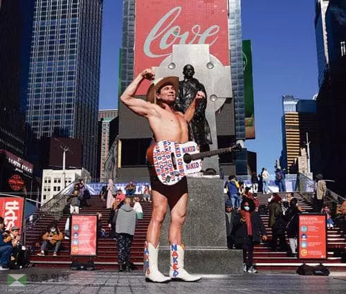 &nbsp;뉴욕 타임스스퀘어에서 관광객을 상대로 영업하는‘네이키드 카우보이’ 로버트 벅이 사진 포즈를 취하고 있다. [로이터]