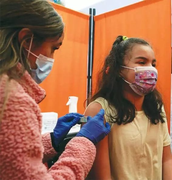 샌프란시스코의 백신 접종소에서 한 어린이가 마스크를 쓰고 백신을 맞고 있다. 
<Mike Kai Chen for The New York Times>