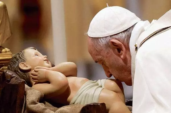 프란치스코 교황이 크리스마스이브 행사에서 아기 예수 조각상에 입맞춤하고 있다. [로이터]
