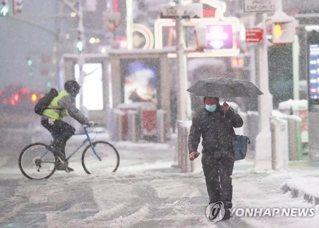  7일 눈 폭풍이 몰아치는 뉴욕 거리를 행인과 자전거를 탄 사람이 힘겹게 지나가고 있다.