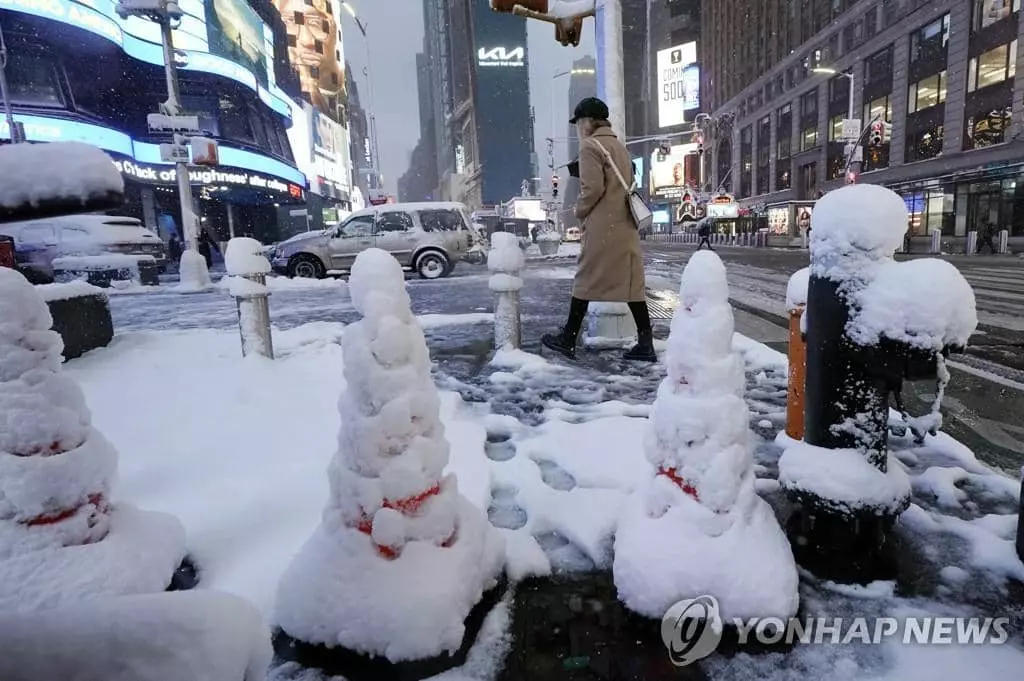 동부에 7일 겨울 폭풍이 몰아치면서 폭설이 내려 뉴욕 타임스스퀘어 광장에 상당량의 눈이 쌓인 가운데 인적이 드문 광장 인근 길을 한 여성이 지나가고 있다. 