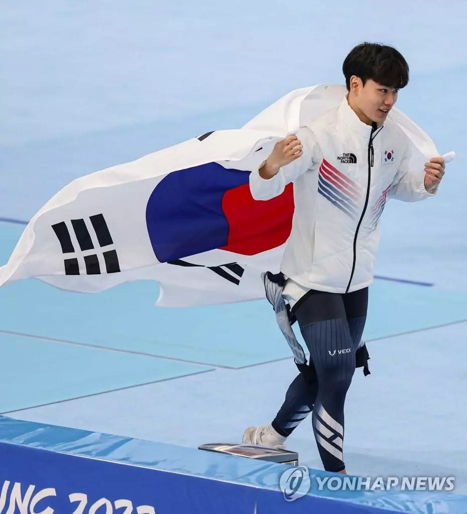 대한민국의 김민석이 8일 오후 중국 베이징 국립 스피드스케이팅 경기장(오벌)에서 열린 2022 베이징 동계올림픽 스피드스케이팅 남자 1,500m 경기에서 동메달을 획득한 후 태극기를 두르고 자축하고 있다.