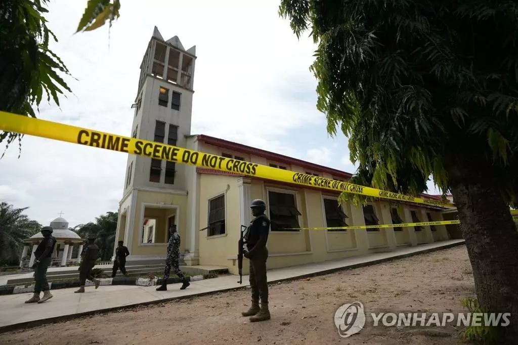 6일(현지시간) 나이지리아 남서부 온도주의 성 프란치스코 성당 주변에서 경찰이 경계를 서고 있다. 전날 미사가 진행 중인 이 성당에서 무장 괴한들이 총기를 무차별 난사해 최소 50명이 목숨을 잃은 것으로 전해졌다. 