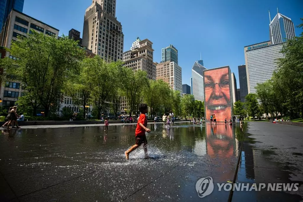 14일 시카고 시내의 크라운 분수대에서 한 아이가 물놀이하고 있다. 미국 국립기상청이 폭염주의보를 발령함에 따라 시카고 대도시권은 이에 대비해 폭염 대피 시설인 '쿨링 센터'를 운영할 예정이다.