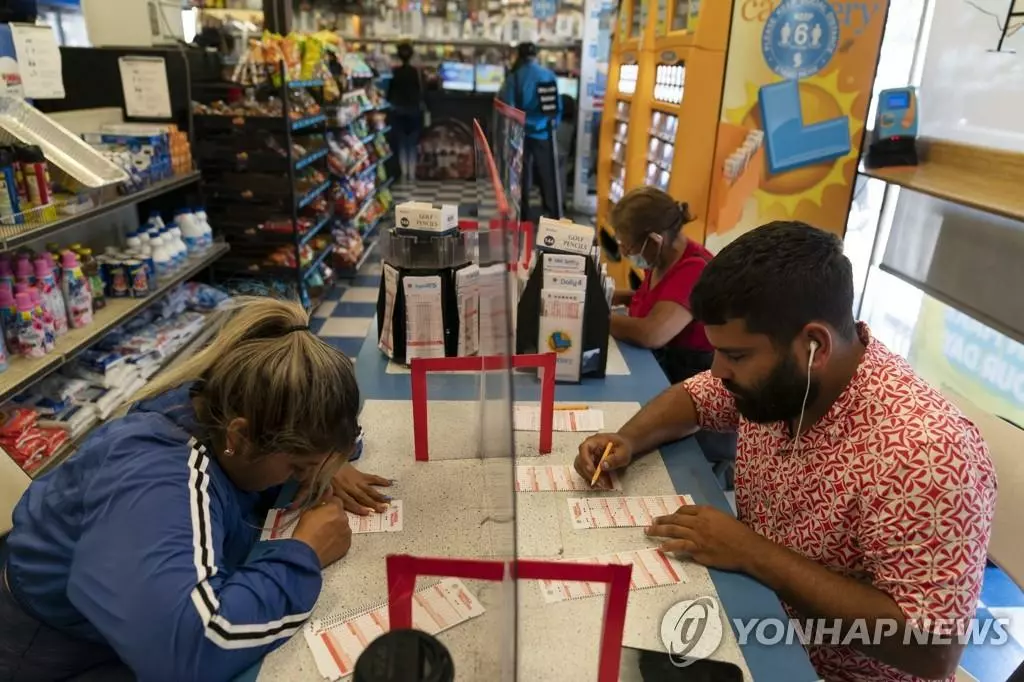 캘리포니아주 호손의 한 복권 판매점을 찾은 주민들이 메가 밀리언스 복권에 숫자를 기입하고 있다. 미국 양대 복권 중 하나인 '메가 밀리언스'는 3개월 동안 1등 당첨자가 나오지 않아 '잭폿'(1등) 상금이 10억 달러로 불어난 상태다. 