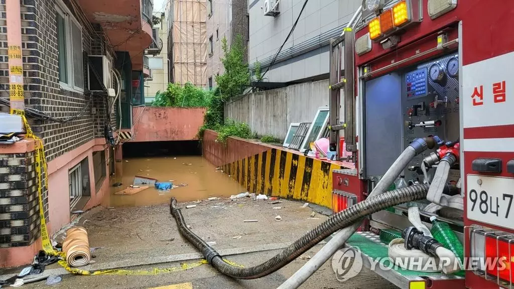  지난 8일 오후 9시 7분께 서울 관악구 부근 한 빌라 반지하에 폭우로 침수된 일가족 3명이 갇혀 신고했지만 결국 사망했다. 주민들에 따르면 사고가 난 빌라 바로 앞 싱크홀이 발생해 물이 급격하게 흘러들었고, 일가족이 고립돼 구조되지 못했다. 사진은 침수된 빌라 배수작업.