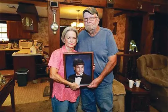 미국 마약단속국 간부 해롤드 듀안 풀이 쏜 총에 맞아 숨진 이웃 체이스 브루어의 고등학교 졸업 사진을 그의 부모가 9일 미시시피주 카펜터 집에서 들고 있다.<연합>
