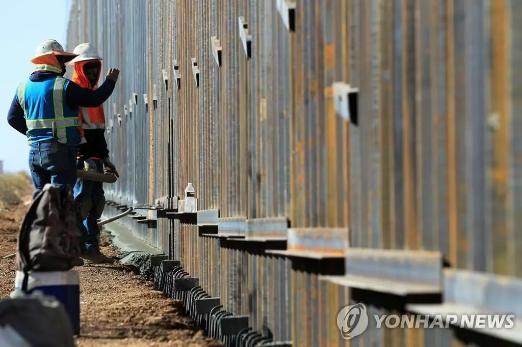  2020년 12월 2일 뉴멕시코주 콜럼버스 카운티와 멕시코 치와와주 푸에르토 팔로마스시 접경 지역에서 미 건설회사 '얼티미트 콘크리트'의 노동자들이 도널드 트럼프 미국 대통령의 명령으로 건설 중인 철제 국경 장벽의 마무리 작업을 서두르고 있다. 이 작업에 참여하는 건설 회사들은 조 바이든 미 대통령 당선인의 임기가 시작되는 2021년 1월 20일 이전 작업을 완료하기 위해 박차를 가하고 있다. 