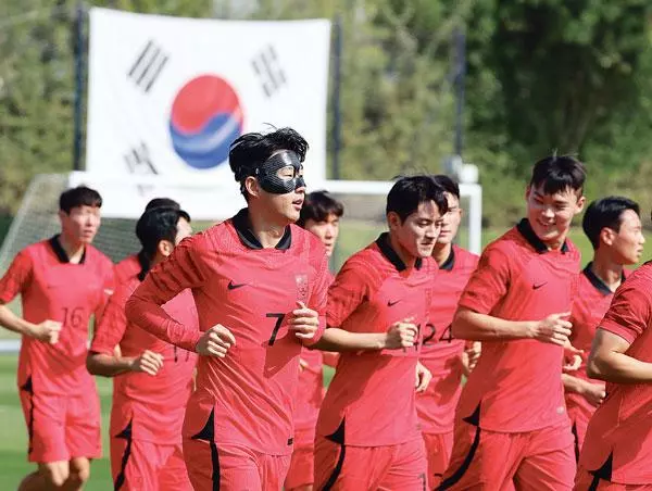  안면보호대를 착용한‘캡틴’손흥민(왼쪽 두 번째) 등 축구 국가대표팀 선수들이 16일 오전 카타르 도하의 알에글라 훈련장에서 진행된 첫‘완전체’ 훈련에서 러닝을 하며 몸을 풀고 있다. [연합]