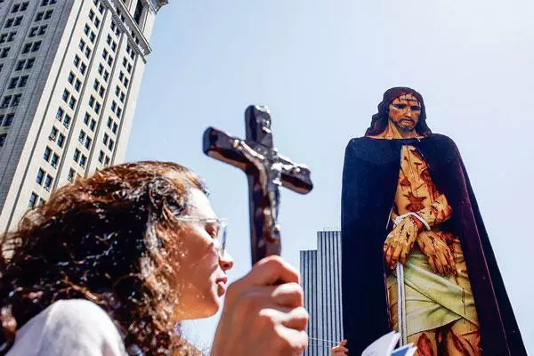  한 여성 기독교인이 예수상 앞에서 십자가를 들고 있는 모습으로 기사 내용과 직접 관계없음. [로이터]