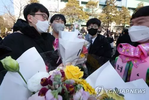 4일 서초구 서울고등학교에서 열린 졸업식을 마친 한 졸업생이 교회 형, 누나들의 축하를 받고 있다.