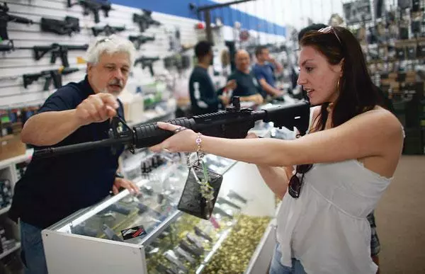  미국에서 여전히 총기 소유는 헌법이 보장한 권리라는 인식이 뿌리깊이 박혀있다. 50개 주마다 들쑥날쑥 규제로 여전히 총기를 소유하기는 쉽다. 플로리다 주의 한 총포상에서 여성이 반자동 소총을 들여다보고 있다. [로이터]