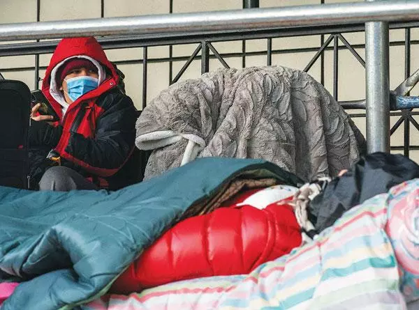 뉴욕으로 이송된 국경 난민신청 이민자들이 구호센터로 쓰이던 호텔 앞에서 노숙을 하고 있다. [로이터]