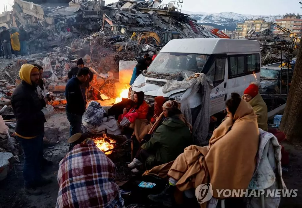 모닥불에 몸 녹이는 튀르키예 강진 피해자들(카흐라만마라슈 로이터=연합뉴스)= 8일(현지시간) 튀르키예 남부 카흐라만마라슈시에서 지진 피해자들이 무너진 건물 잔해 옆에서 모닥불을 피워 몸을 녹이고 있다. 지난 6일 시리아와 인접한 튀르키예 남동부에서 규모 7.8, 7.5의 강진이 잇따라 발생해 지금까지 양국에서 1만1천명 이상이 사망한 것으로 집계됐다. 