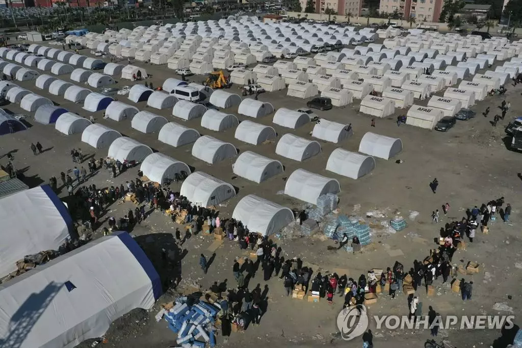 (이스켄데룬 AP=연합뉴스) 지진 발생 9일째인 14일(현지시간) 튀르키예 남부도시 이스켄데룬의 임시 캠프에서 이재민들이 구호품을 받으려고 줄서있다. 지난 6일 튀르키예와 시리아를 덮친 대지진으로 건물이 대거 무너져 지금까지 양국에서 4만1천명 이상이 사망했다. 집을 잃고 임시 캠프에서 지내는 이재민이 튀르키예에서만 100만명이 넘는다.