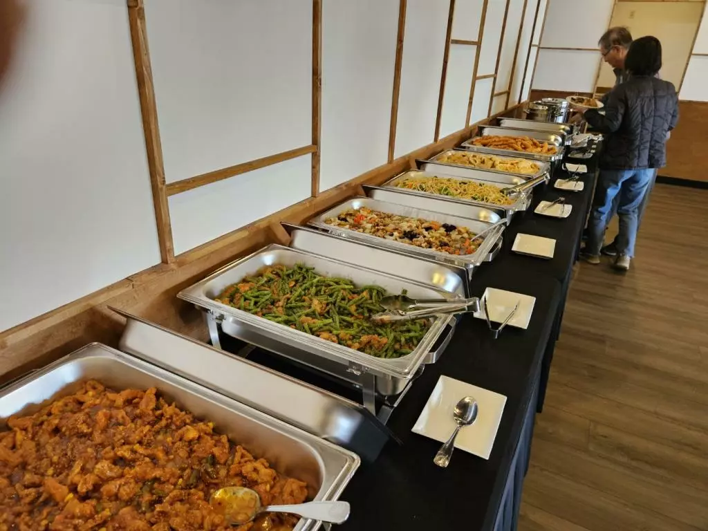 지난 11일 둘루스 중한식당의 주말 브런치 요리 진열대에서 손님들이 음식을 쟁반에 담고 있다.