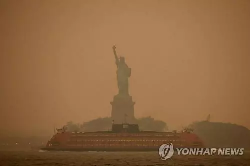 6일 캐나다에서 번진 산불 연기 여파로 뉴욕시 자유의 여신상 일대 대기가 뿌옇게 변해 있다. (뉴욕 로이터=연합뉴스) 