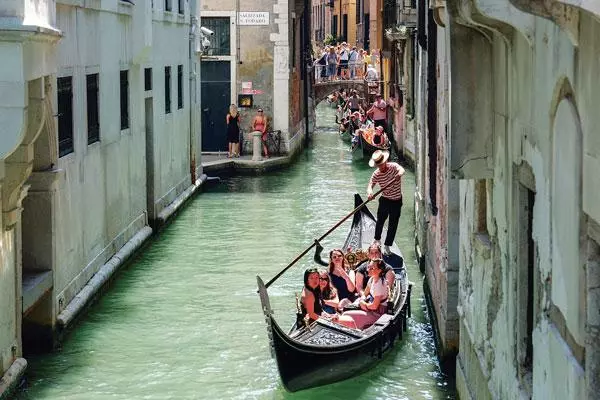  이탈리아 북부 수상도시 베네치아에서 관광객들이 곤돌라를 타고 있다. 이날 유네스코는 기후변화와 과잉 관광으로 시달려온 베네치아를 위험에 처한 세계유산 목록에 등재하고 보호해야 한다고 권고했다. [로이터]