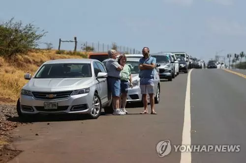 9일 하와이 마우이섬에서 산불로 도로가 통제돼 여행객들이 대기 중인 모습.[로이터=연합뉴스. 재판매 및 DB 금지]