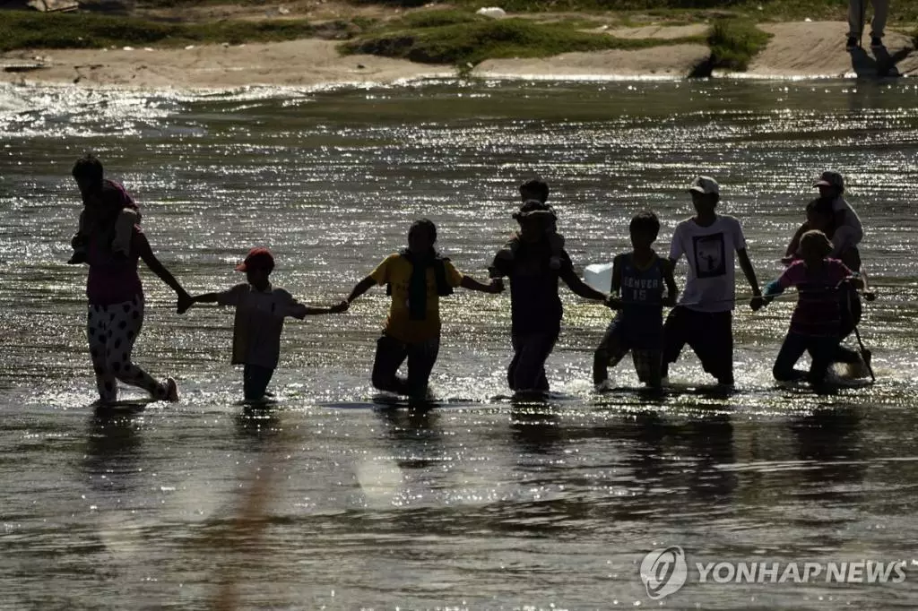 미국 입국을 꿈꾸는 이주민들이 21일(현지시간) 손을 맞잡고 '인간 띠'를 만들어 미국과 국경을 접한 멕시코의 리오그란데강을 건너고 있다. 지난 5월 미국의 불법 입국자 즉시 추방 정책(42호 정책) 종료 직후 감소했던 불법 이민자 수가 최근 다시 반등했다. <연합뉴스>